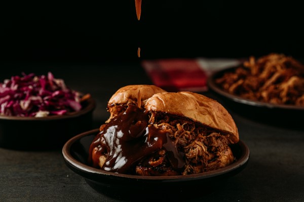 Sanduche de pulled pork en plato con salsa bbq